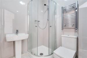 a bathroom with a shower and a toilet and a sink at Modern Designer Studio Flat London in London