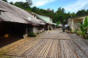 ein Holzsteg neben einer Gruppe von Gebäuden in der Unterkunft Steffan Family Stay in Kampong Teng