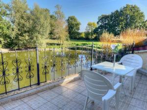 a patio with a table and chairs and a fence at Gîte de charme XVIIe siècle avec jardin clos, balnéo, terrasse panoramique et WIFI près du Château de Villandry - FR-1-381-471 in Villandry