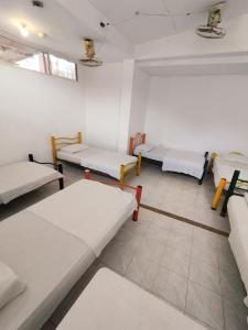 Cette chambre comprend 3 lits et un canapé. dans l'établissement Sierraventura Hostel, à Taganga