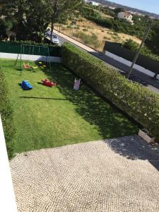 
a park with lawn chairs and lawn furniture at Villa Roja Pé in Albufeira
