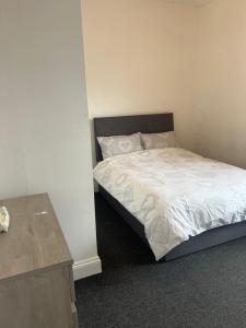 a small bedroom with a bed with white sheets at East Street in Kent