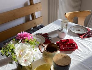 uma mesa com pratos e um vaso de flores em Weberhof em Samerberg