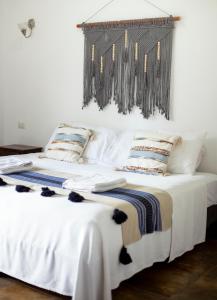 um quarto com uma cama com lençóis brancos e almofadas em hotel stella maris tulum em Tulum