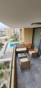 eine Terrasse mit Sofas und Stühlen auf dem Balkon in der Unterkunft departamento Arica verano 2 habitaciones in Arica