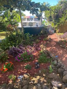 a boat is parked in a garden with flowers at Cozy jungle boat hideaway with stunning ocean view in Kealakekua