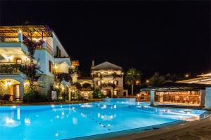 a large swimming pool in front of a building at night at Hadrian Hotel in Kaş