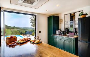 una cocina con armarios verdes y una gran puerta corredera de cristal en Beautiful Home In Pisarovina With Wi-fi en Lipnica