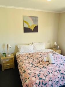 a bedroom with a bed with a floral bedspread at Tee Off Milura in Mildura
