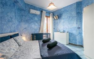 een blauwe slaapkamer met een bed met 2 kussens erop bij 2 Bedroom Amazing Apartment In Giardini Naxos in Giardini Naxos