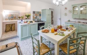 una cocina con armarios azules y una mesa con comida. en 3 Bedroom Gorgeous Home In Palazzetto Nese, en Vicolo Rancolfo