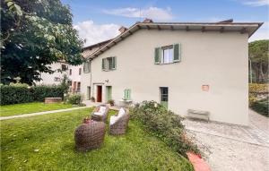 una casa blanca con dos sillas de mimbre en el patio en 3 Bedroom Gorgeous Home In Palazzetto Nese, en Vicolo Rancolfo