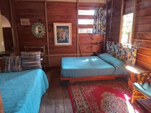 Un dormitorio con dos camas en una cabaña de madera. en La Troje Cabañas, en Tepoztlán
