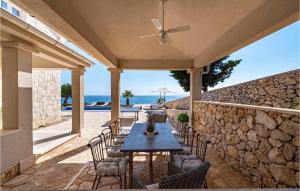 a patio with a table and chairs and a stone wall at Villa Toma in Škunca +48 photos