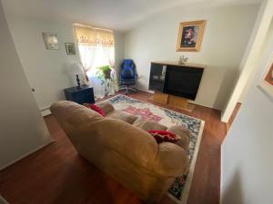 uma sala de estar com um sofá e uma televisão em Two bedroom, living/dining room em Bellport
