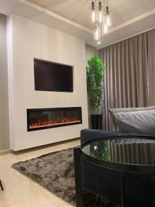 ein Wohnzimmer mit einem TV und einem Kamin in der Unterkunft Appartement de luxe ,piscine,parking,Terrasse in Agadir