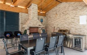 eine Küche mit einem Tisch und Stühlen sowie einem Kamin in der Unterkunft Pet Friendly Home In Rebici With Heated Swimming Pool in Rebići