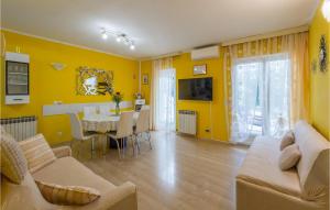 a living room with yellow walls and a table and chairs at Stunning Home In Porec With Wifi in Poreč