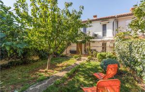a yard with an orange chair in front of a house at Stunning Home In Porec With Wifi in Poreč