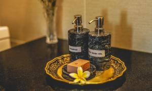 two bottles of soap and a yellow flower on a table at JingLand Hotel Luangprabang in Luang Prabang