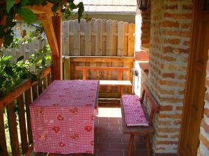 a patio with two benches and a table and a fence at Anna Lak in Magyarszombatfa
