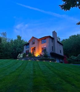 een huis op een heuvel met de lichten aan bij Villa Verde B&B, bsm, Greenwood Lake, NY in Monroe