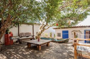 una terraza de madera con una mesa de picnic bajo un árbol en Paradiso Hostel & Suites - TOP 1 DE SÃO PAULO, en São Paulo