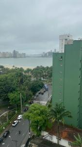 un grand bâtiment vert à côté d'un parking dans l'établissement Biquinha - Praça 22 de Janeiro, à São Vicente