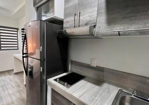 cocina con nevera de acero inoxidable y fregadero en LONGVIEW HOME-STUDIOS, en Tepic