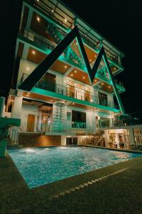 a building with a swimming pool at night at The Marc Vannelli Oslob in Oslob