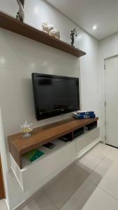 ein Wohnzimmer mit einem Flachbild-TV an der Wand in der Unterkunft Biquinha - Praça 22 de Janeiro in São Vicente