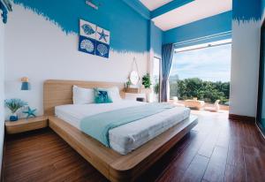 a bedroom with a large bed and a large window at Blossom Sea Homestay Quy Nhơn in Quy Nhon
