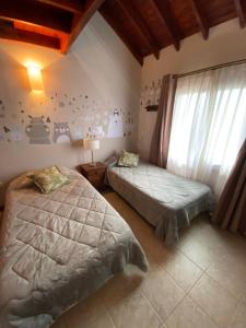 een slaapkamer met 2 bedden en een raam bij Lirios del Campo - Chumamaya Merlo SL in Merlo