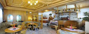 un ristorante con due tavoli e un bar di Hotel Rosalpina a Rocca Pietore