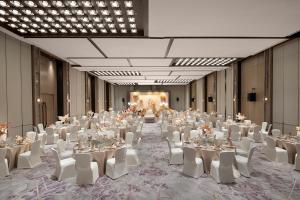 un gran salón de banquetes con mesas blancas y sillas blancas en Crowne Plaza Shanghai Jinxiu, an IHG Hotel, en Shanghái