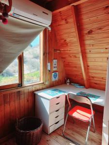 une chambre avec un bureau et une chaise dans une cabine dans l'établissement El Canto de la Ballena, à Puerto Pirámides