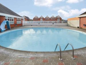 a large blue swimming pool with a slide in it at 4 star holiday home in Rømø-By Traum in Sønderby
