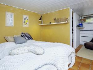 um quarto com uma cama branca e uma parede amarela em Holiday home Rørvig XIII em Rørvig