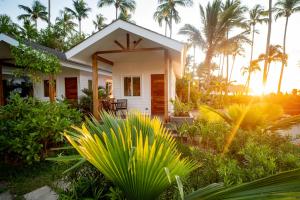 a small white house with palm trees in the background at Nacpan Beach Villas in El Nido