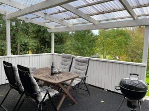 a patio with a table and chairs and a grill at Holiday home SURAHAMMAR in Surahammar