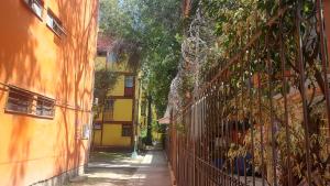 an alley between two buildings with a fence at Cómoda y tranquila recámara cerca de Aeropuerto Benito J baño compartido in Mexico City