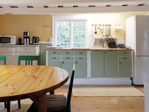 uma cozinha com armários verdes e uma mesa de madeira em Holiday home Björklinge em Björklinge