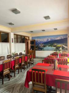 a restaurant with red tables and chairs and a painting at Ifseen Villa in Pelling