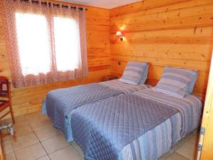 ein Schlafzimmer mit zwei Betten in einer Blockhütte in der Unterkunft Chalet au calme avec sauna, proche des pistes, parking - FR-1-598-123 in Les Gets