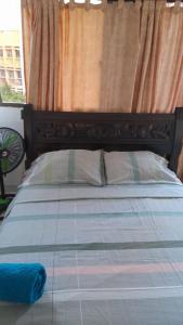 ein Schlafzimmer mit einem Bett mit einem Kopfteil aus Holz in der Unterkunft EDIFICIO MENDEZ in Cartagena de Indias