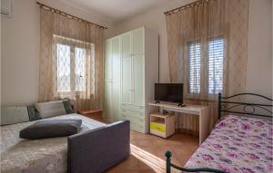 1 dormitorio con 1 cama y escritorio con TV en Cozy Apartment In Miglianico With Wifi, en Miglianico
