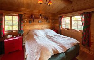 a bedroom with a bed in a log cabin at Beautiful Home In Sjusjen With 3 Bedrooms in Sjusjøen
