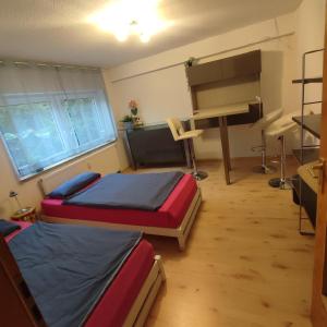 a room with two beds and a desk in it at Siebeneichen in Affalterbach