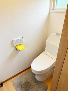 uma casa de banho com WC e uma placa na parede em Kohan no yado Kojima em Lago Toya