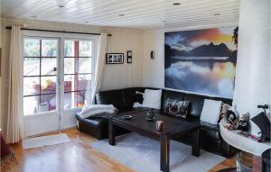 5 Bedroom Nice Home In Noresund في Noresund: غرفة معيشة مع أريكة سوداء وطاولة